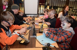 Kids soldering electronic kits at Madlab workshop