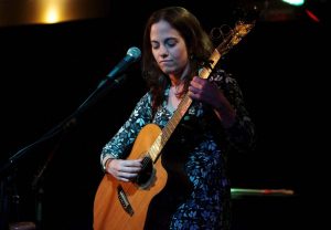 Close Photo of Shawna Caspi playing guitar on stage