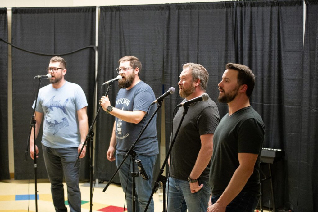 The four men of the Bytown Sea Shanty Collective sing in The Now Room, and the audience sang along