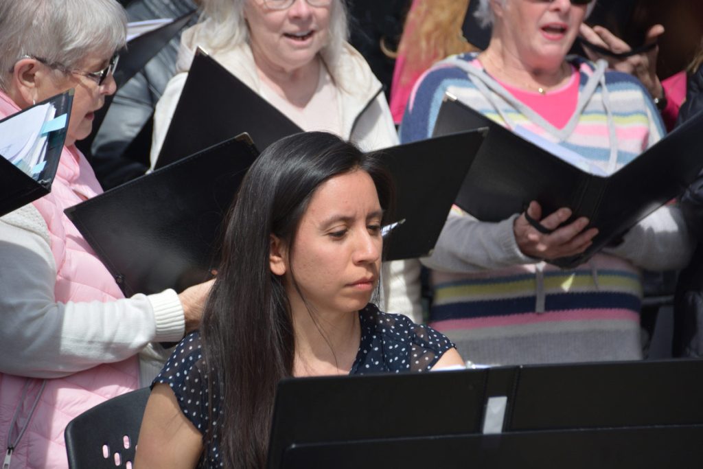 The choir's accompanist plays with singers behind her